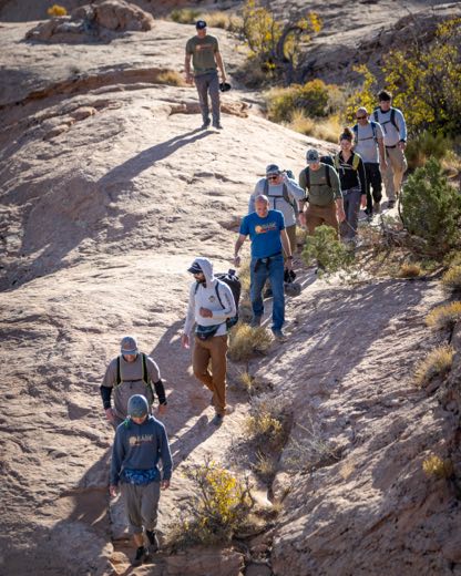 Veterans hiking together on slickrock during a 22 Jumps retreat