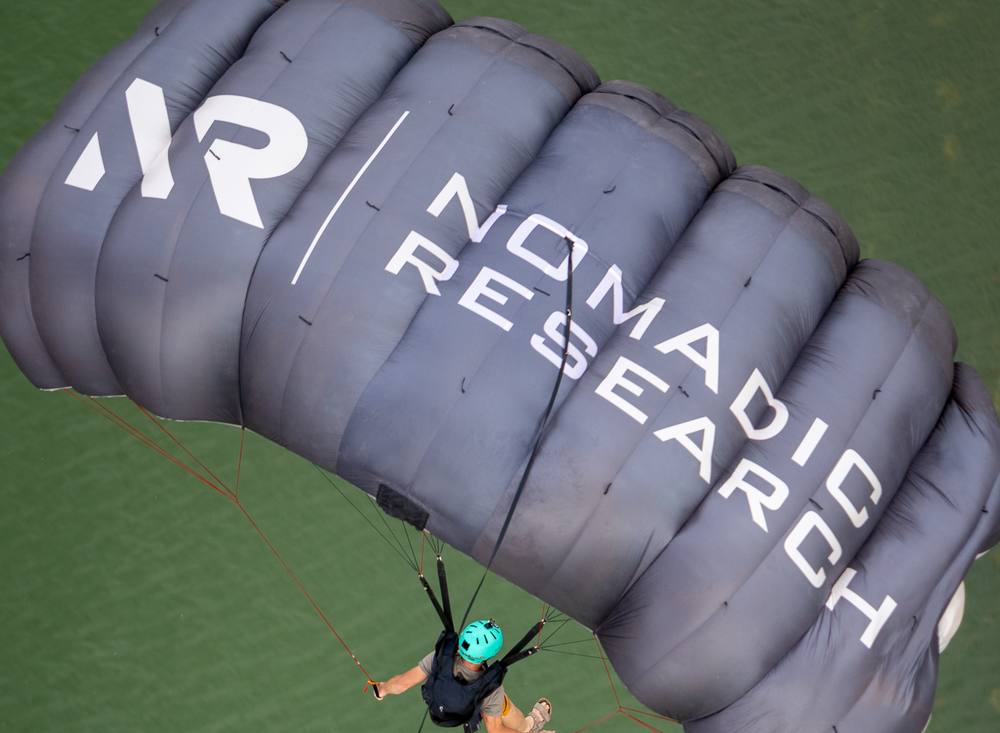 A jumper under a custom branded canopy over the water